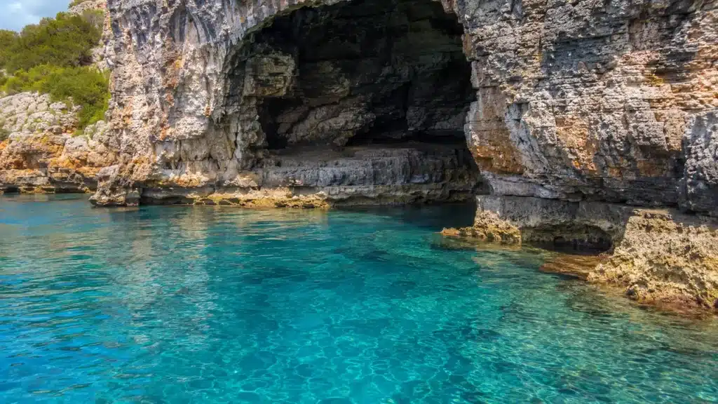 Helle Kalksteinfelsen und klares Meer an der Küste bei Porto Cristo